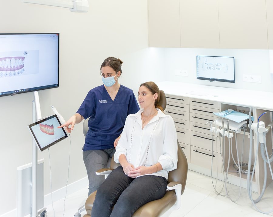 Empreinte optique : la praticienne montre à la patiente son modèle 3D sur l'écran du scanner intra-oral